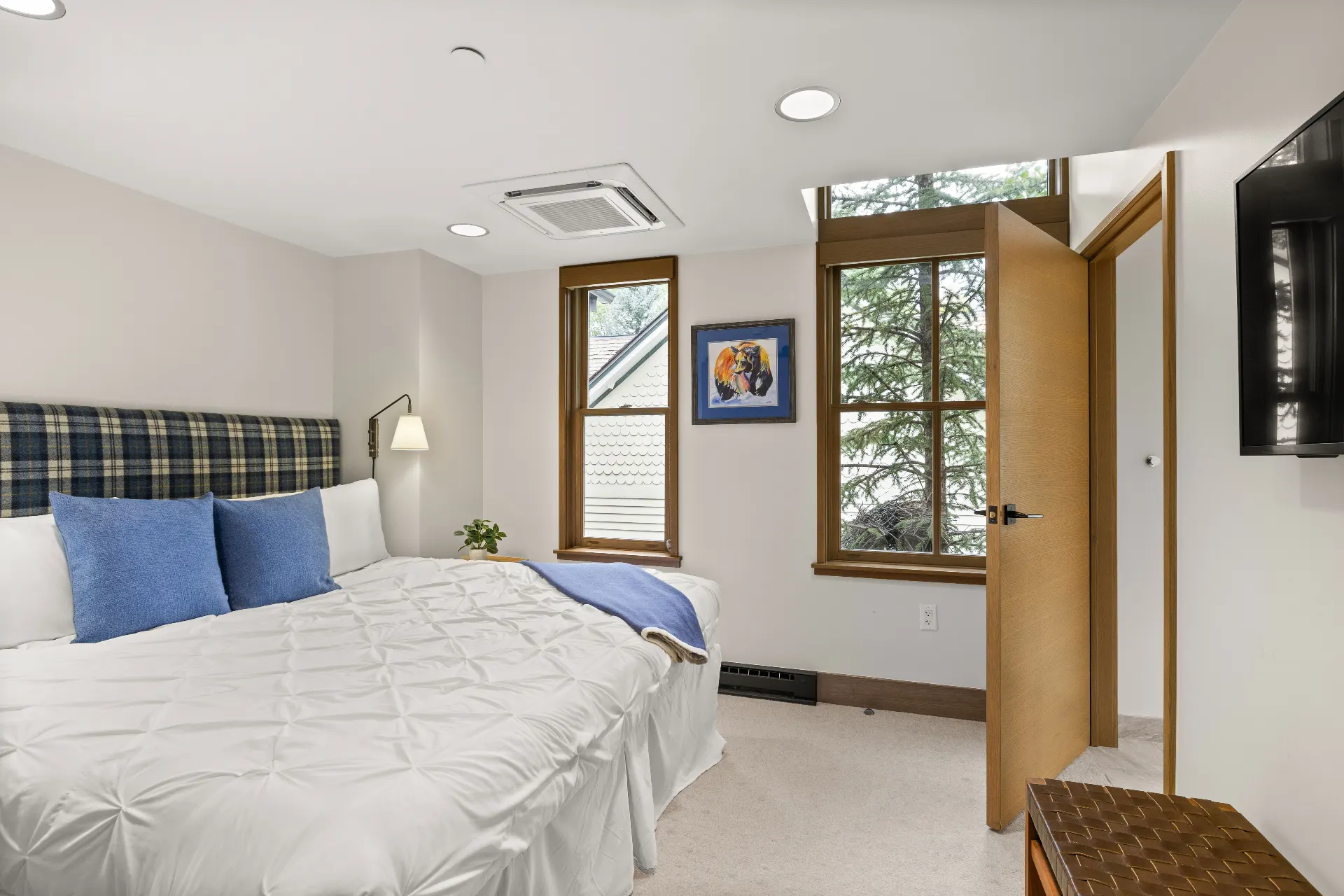 Cozy bedroom with plaid headboard and mountain art